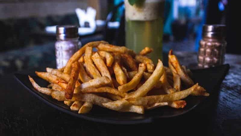 Gélules de Garcinia Cambogia à côté du fruit, symbolisant son usage comme complément minceur.